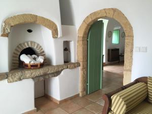 a living room with a stone fireplace with a green door at Villa Lemonia - Guest House in Aroniadika