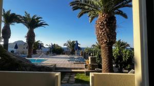 SellíaにあるSouda Bay Apartmentsのヤシの木とプールのあるリゾートの景色を望めます。