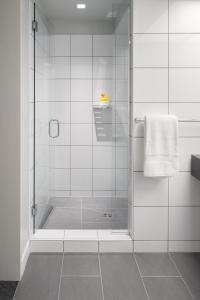 a shower with a glass door in a bathroom at Fordson Hotel, in the Unbound Collection by Hyatt in Oklahoma City