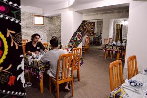 two people sitting at a table in a restaurant at Boutique Old City in Bukhara