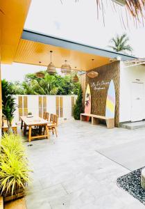 a patio with a table and a surfboard on a wall at Villa De Phawa At Amphawa in Samut Songkhram