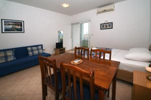 a living room with a dining table and a bed at Apartments Ćorić in Baška Voda
