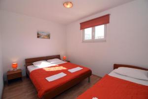 a bedroom with two beds and a window at Apartments Ćorić in Baška Voda