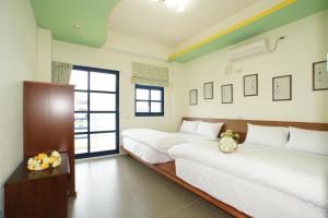 台東市的住宿－翔揚嵐天地中海民宿，一间卧室设有两张床和窗户。