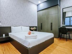 a bedroom with a bed with a desk and a chair at HighClass Suites - Walk-To-Independence Palace, SaiGon's Heart in Ho Chi Minh City