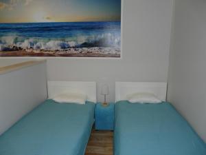two beds in a room with a painting on the wall at Apartament Bluesky in Świnoujście