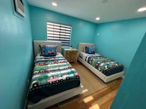 two beds in a room with blue walls at Coastal Calm Casita in Long Beach
