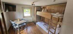 a small room with a bunk bed and a table at Sportpension Penhab in Saalbach Hinterglemm