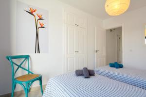 una camera da letto con un letto e una sedia blu di Lanza Coloradas 20, heated pool a Playa Blanca Altre 39 foto