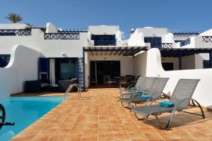 un gruppo di sedie sedute accanto a una piscina di Lanza Coloradas 20, heated pool a Playa Blanca