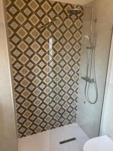 a bathroom with a shower with a tile wall at Camere al Borgo Affittacamere in Monteprandone