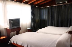 um quarto de hotel com duas camas e uma televisão em Cavo D' Oro em Nea Moudania