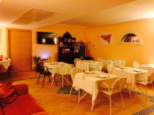 une salle à manger avec des tables et des chaises blanches dans l'établissement Il Principe B&B, à Alì Terme