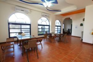 a living room with tables and chairs and windows at Xiang Yang Lan Tian Homestay in Taitung City