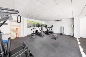 a gym with treadmills and ellipticals in a room at Hotel Ankaa - Adults Only in Porto Cristo