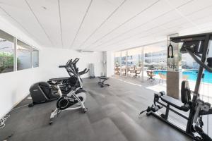 a gym with cardio equipment and a swimming pool at Hotel Ankaa - Adults Only in Porto Cristo