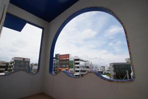 an arched window with a view of a city at Xiang Yang Lan Tian Homestay in Taitung City