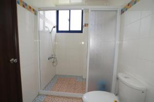a bathroom with a shower and a toilet at Xiang Yang Lan Tian Homestay in Taitung City