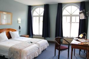 En eller flere senge i et værelse på Hôtel Restaurant La Cigogne