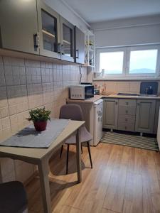 a kitchen with a table and chairs in a room at SKY Apartment in Odorheiu Secuiesc