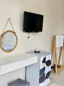 a flat screen tv hanging on a white wall at Homestay Hoa Hồng in Liên Trì (4)