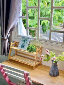 a table with a picture on it next to a window at Homestay Hoa Hồng in Liên Trì (4) +49 photos