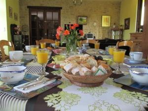 een tafel met een tafelkleed en een kom eten bij Les sources in Poilley