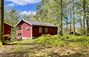 a red house in the middle of a forest at 4 Bedroom Beautiful Home In Hörby in Hörby