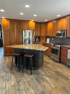 a kitchen with wooden cabinets and a large island with stools at King Home- Mountain Oasis Pool & Views in Pocatello