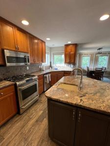 a kitchen with wooden cabinets and a stove top oven at King Home- Mountain Oasis Pool & Views in Pocatello +53 photos
