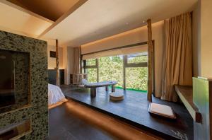 a hotel room with a bedroom with a large window at Xi'an Zhiyin Courtyard Designer Hotel in Xi'an