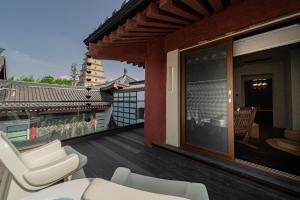 a balcony with white chairs and a sliding glass door at Xi'an Zhiyin Courtyard Designer Hotel in Xi'an