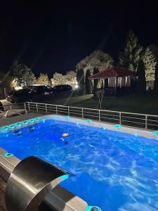 a large blue swimming pool at night at Луксозна вила - Стрелча, джакузи с минерална вода in Strelcha