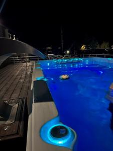 a swimming pool with blue lights in the night at Луксозна вила - Стрелча, джакузи с минерална вода in Strelcha