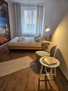 a bedroom with a bed and a chair and a window at Apatments Prague by Yuliia in Prague