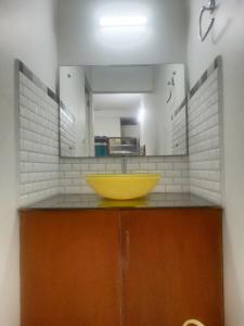 a bathroom with a yellow sink and a mirror at PERIYAR Paradise,Thekkady,kumily in Vandiperiyār