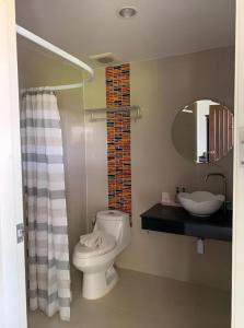 a bathroom with a toilet and a sink and a mirror at Rittiboon Vintage Hotel in Phrae +202 photos