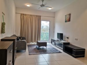 a living room with a couch and a tv and a chair at Ummu's homestay in Tanah Rata