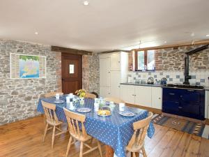 a kitchen with a table with a blue table cloth at Swallows Cottage in Bideford