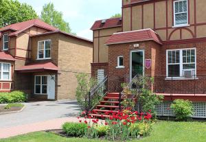 a brick house with red flowers in front of it at Hotel Auberge Michel Doyon in Quebec City