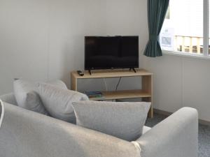 a living room with two chairs and a flat screen tv at The Falcon - Uk45538 in Dyke