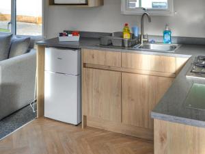 a kitchen with a sink and a white refrigerator at The Falcon - Uk45538 in Dyke