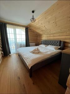 a bedroom with a large bed in a wooden room at BearHouse Chalet in Poiana Mărului