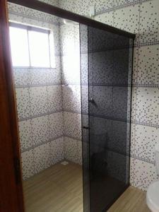 a bathroom with a glass shower with a window at Hotel Sarandi in Foz do Iguaçu
