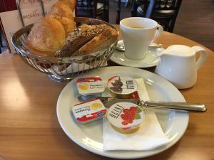 a table with two plates of bread and a cup of coffee at Hotel Falken in Lucerne