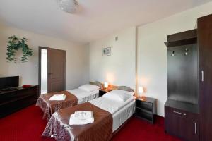 um quarto de hotel com duas camas e uma televisão em Harmonia em Biała Podlaska