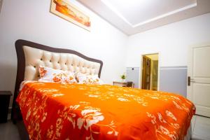 a bedroom with an orange bed with an orange blanket at Chic Studio VIP GOLD Luxe Confort et Élégance à Douala Stade Bonamoussadi in Bonamoussadi