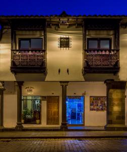 a building with balconies on a street at night at El Virrey Boutique in Cusco