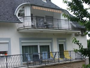 a balcony of a house with chairs on it at Levente Apartman in Balatongyörök