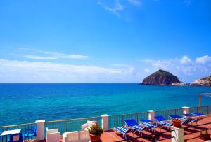 a row of chairs on a balcony overlooking the ocean at Hotel Regina del Mare in Ischia